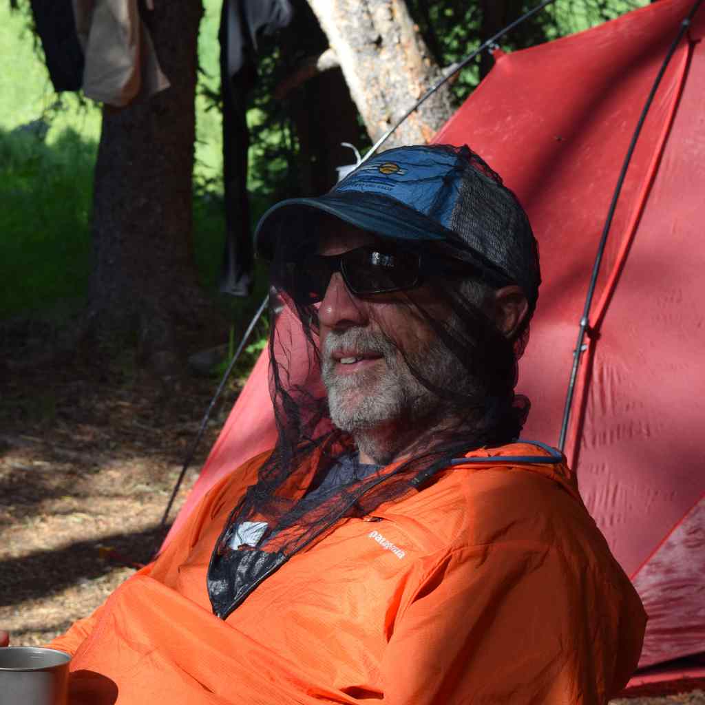 Ben's InvisiNet Head Net man wearing head net in front of red tent wearing orange jacket