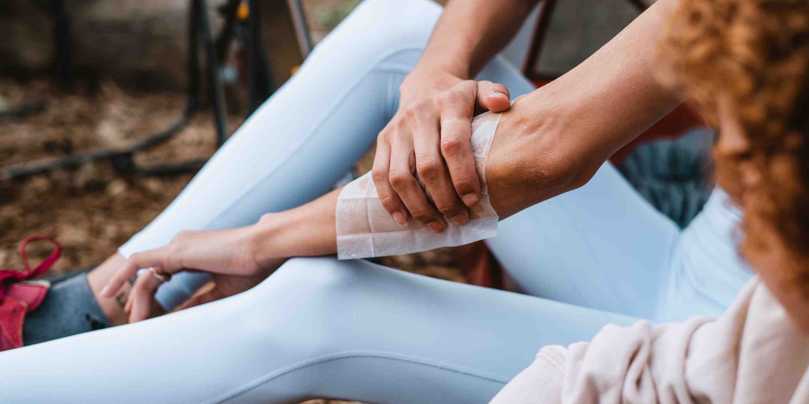 Woman applying Ben's 30 DEET Wipe to arm in blue leggings while camping