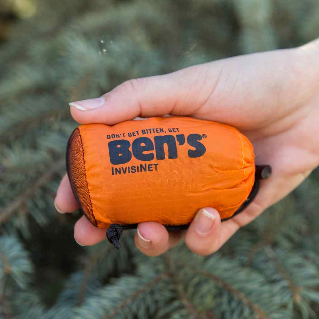 Ben's InvisiNet Head Net holding in sleeve in front of pine trees