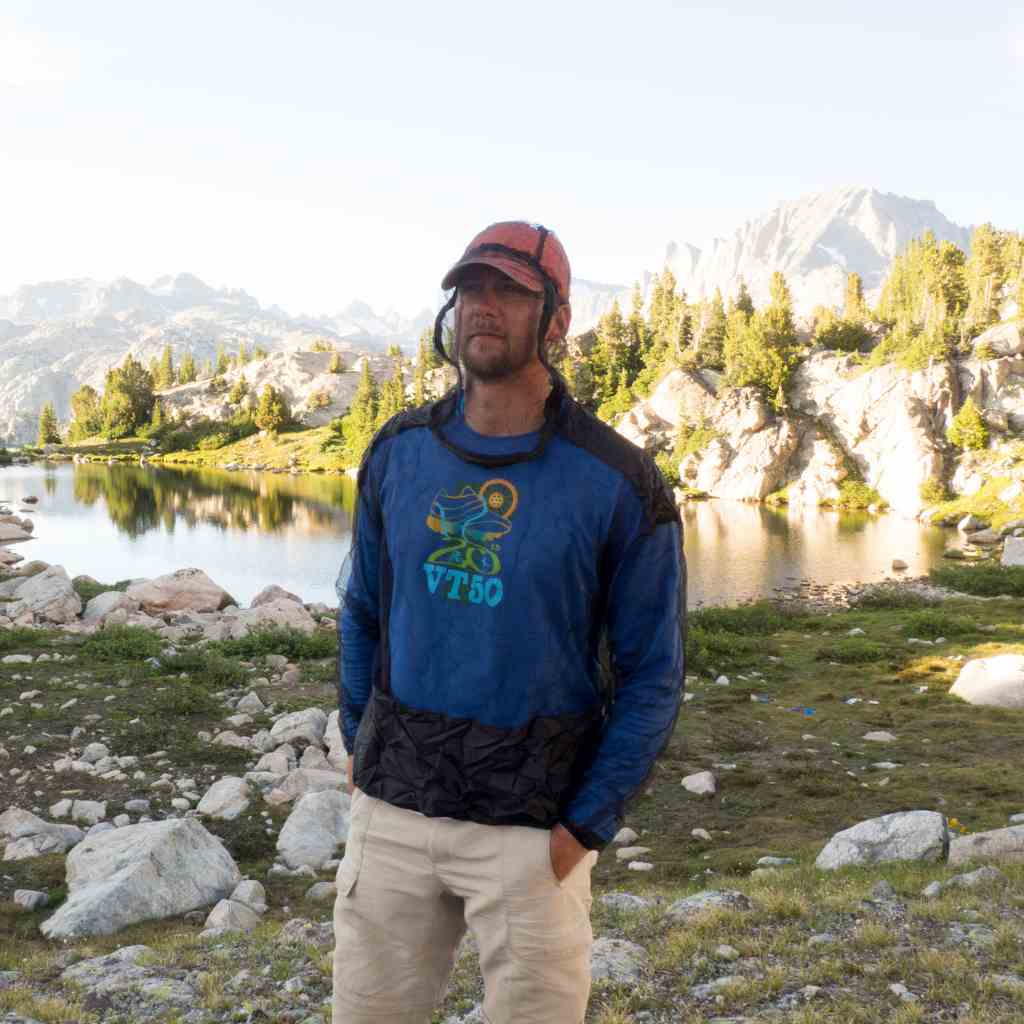 Ben's InvisiNet Bug Jacket & Mitts man wearing jacket in front of pond and rocky mountain area