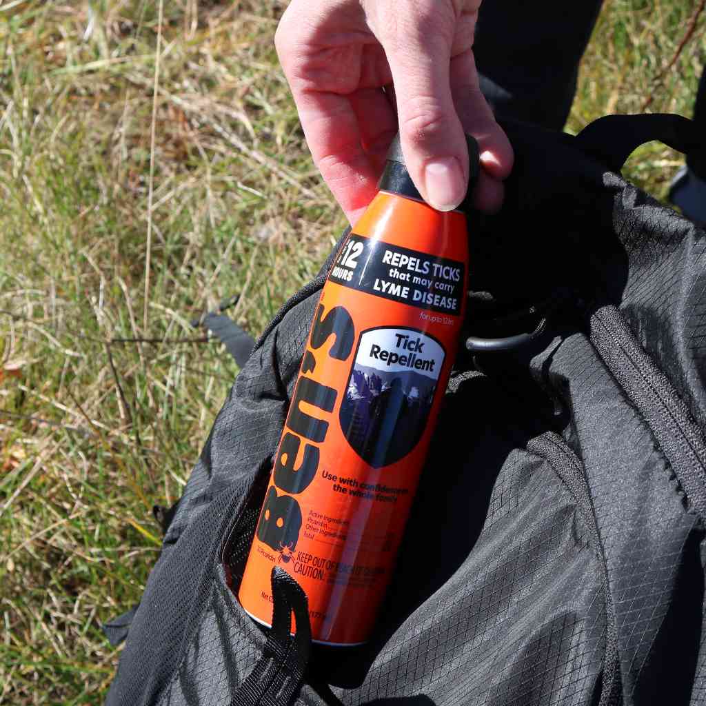 Ben's Tick Repellent 6 oz. Eco-Spray pulling from black backpack pocket